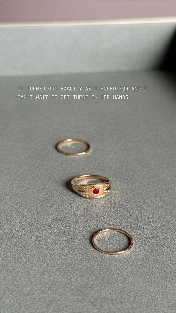 Three gold rings on a gray surface with text above them.