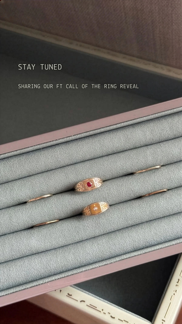 Ring display with three rings on a gray cushion, text indicating anticipation for a ring reveal.