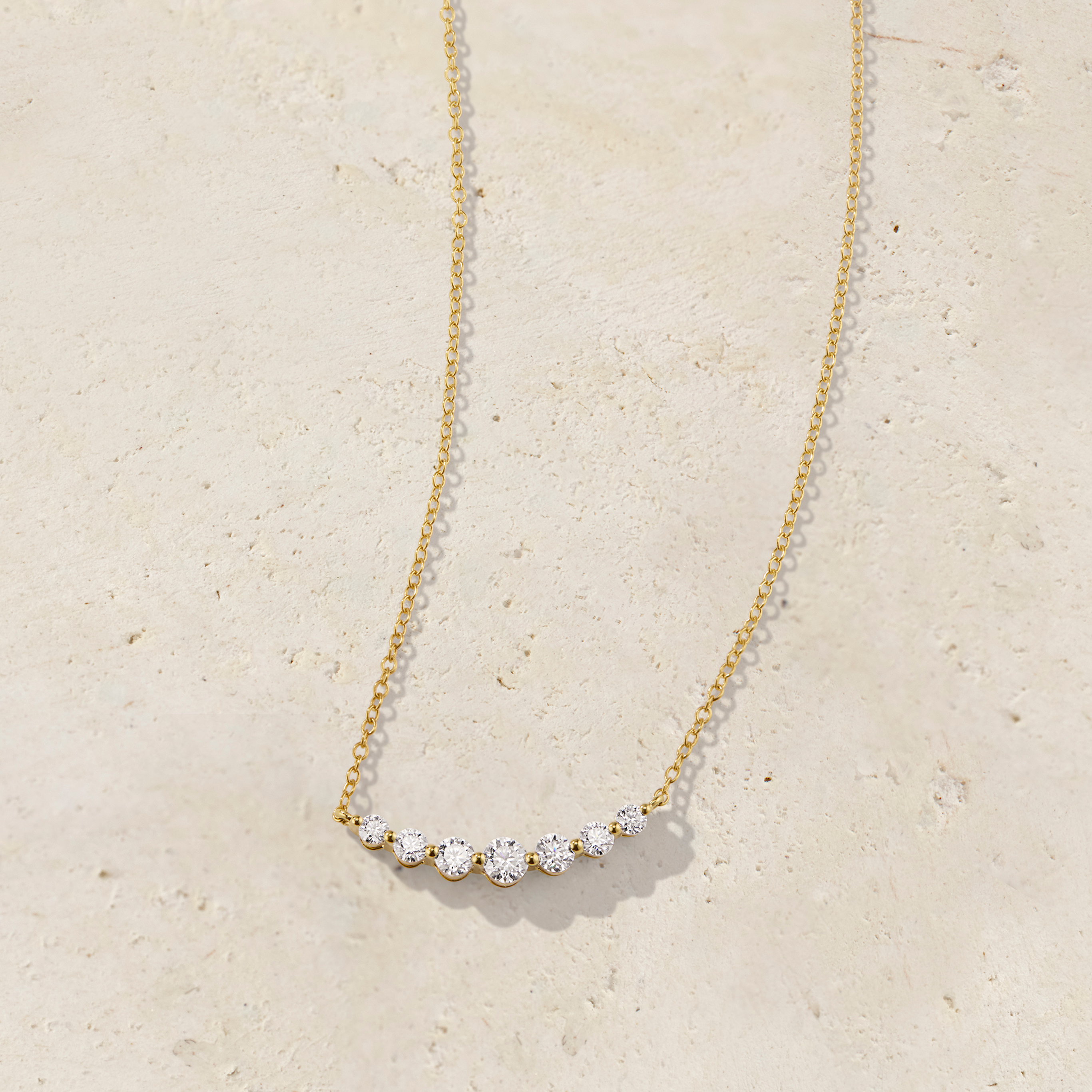 LHUNE 7 Diamond Graduated Necklace in yellow gold, front view of seven graduating round diamonds on slim cable chain