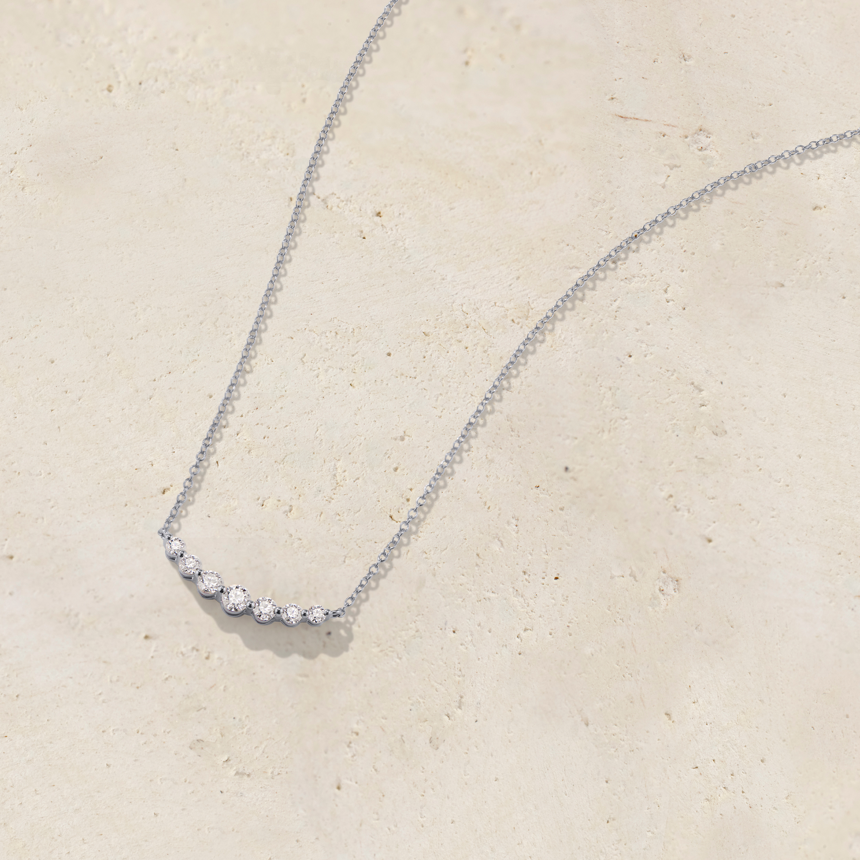 LHUNE 7 Diamond Graduated Necklace, front view of seven graduating round diamonds on slim cable chain