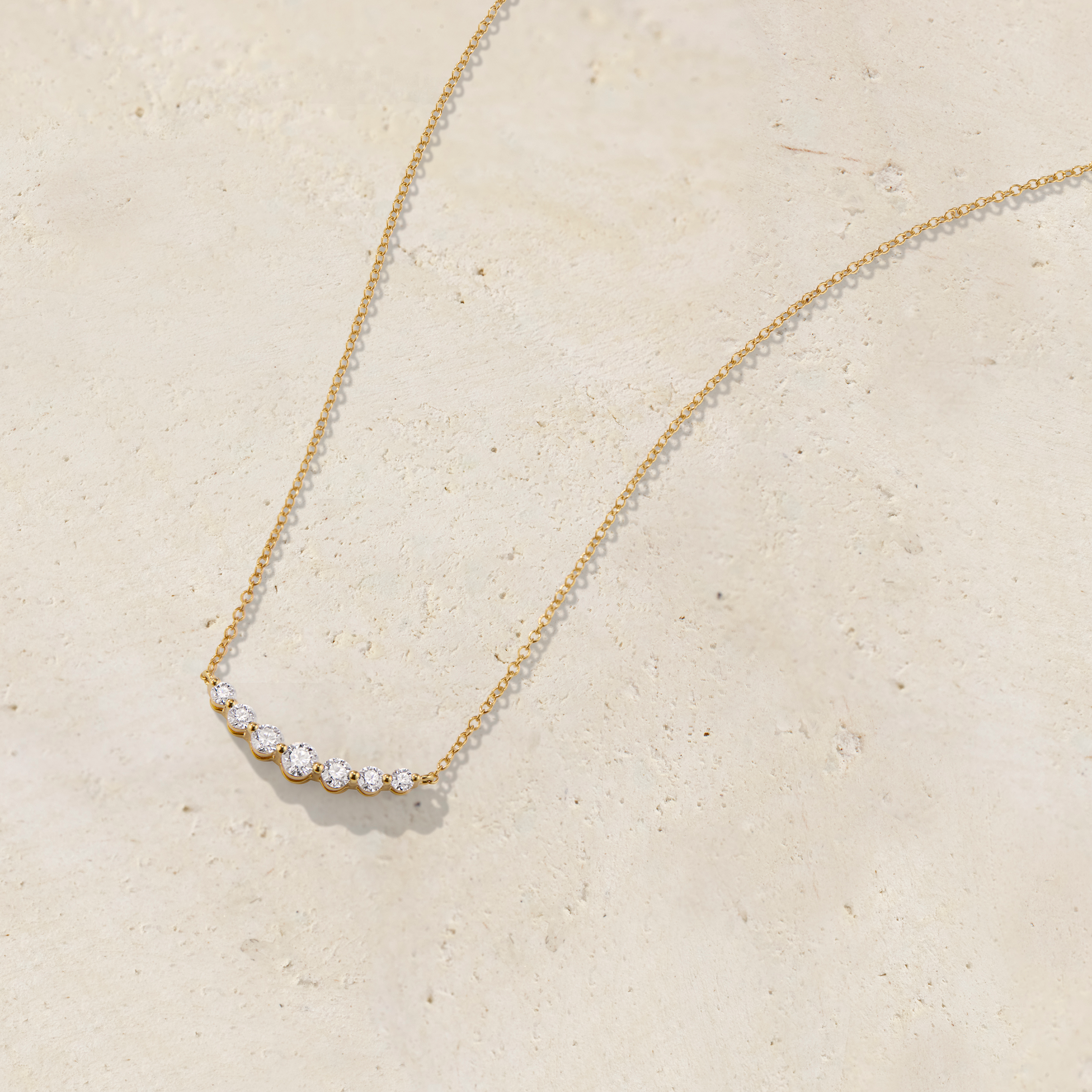 LHUNE 7 Diamond Graduated Necklace in yellow gold, angled upright view of seven graduating diamonds on cable chain