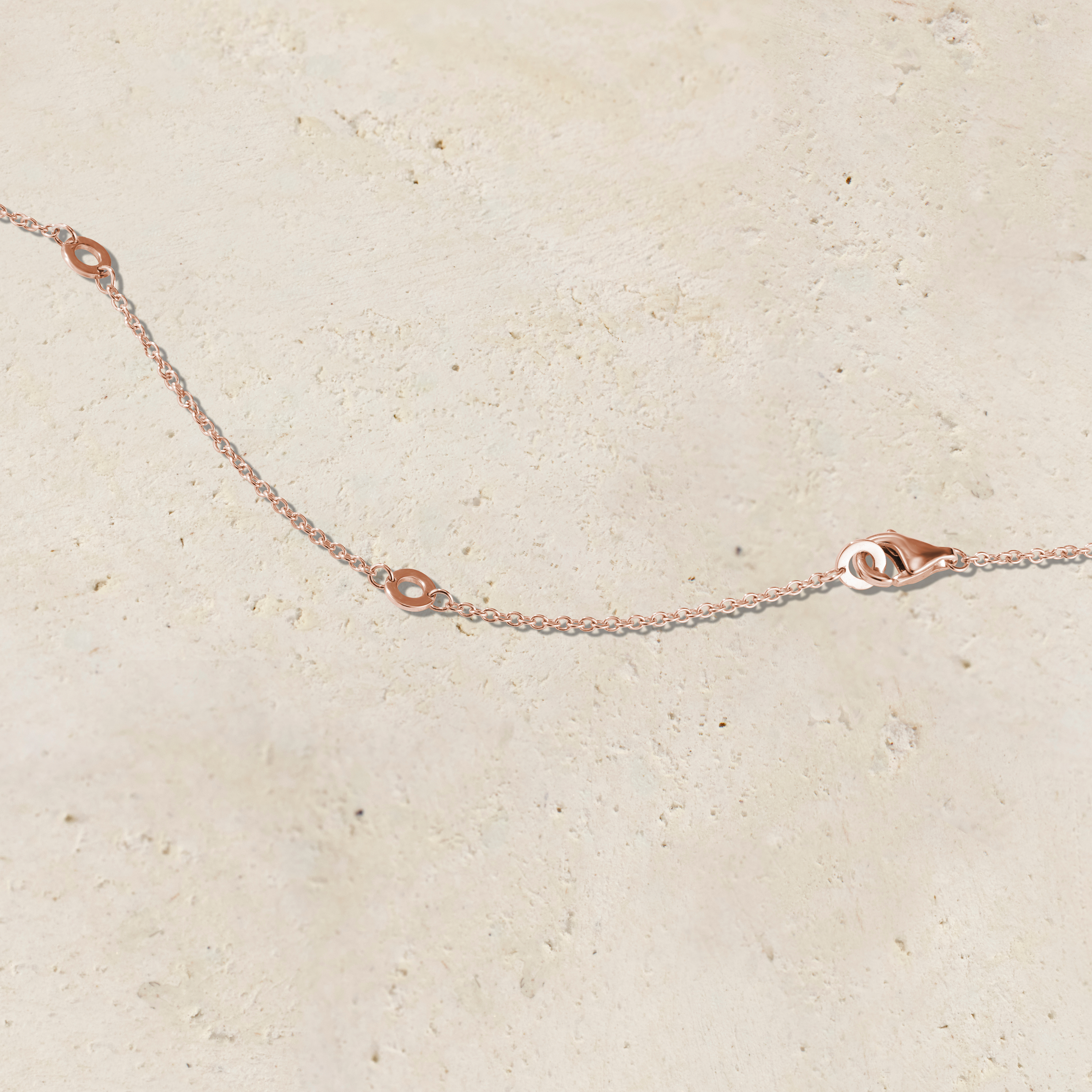 LHUNE 7 Diamond Graduated Necklace, clasp and chain detail on warm stone surface