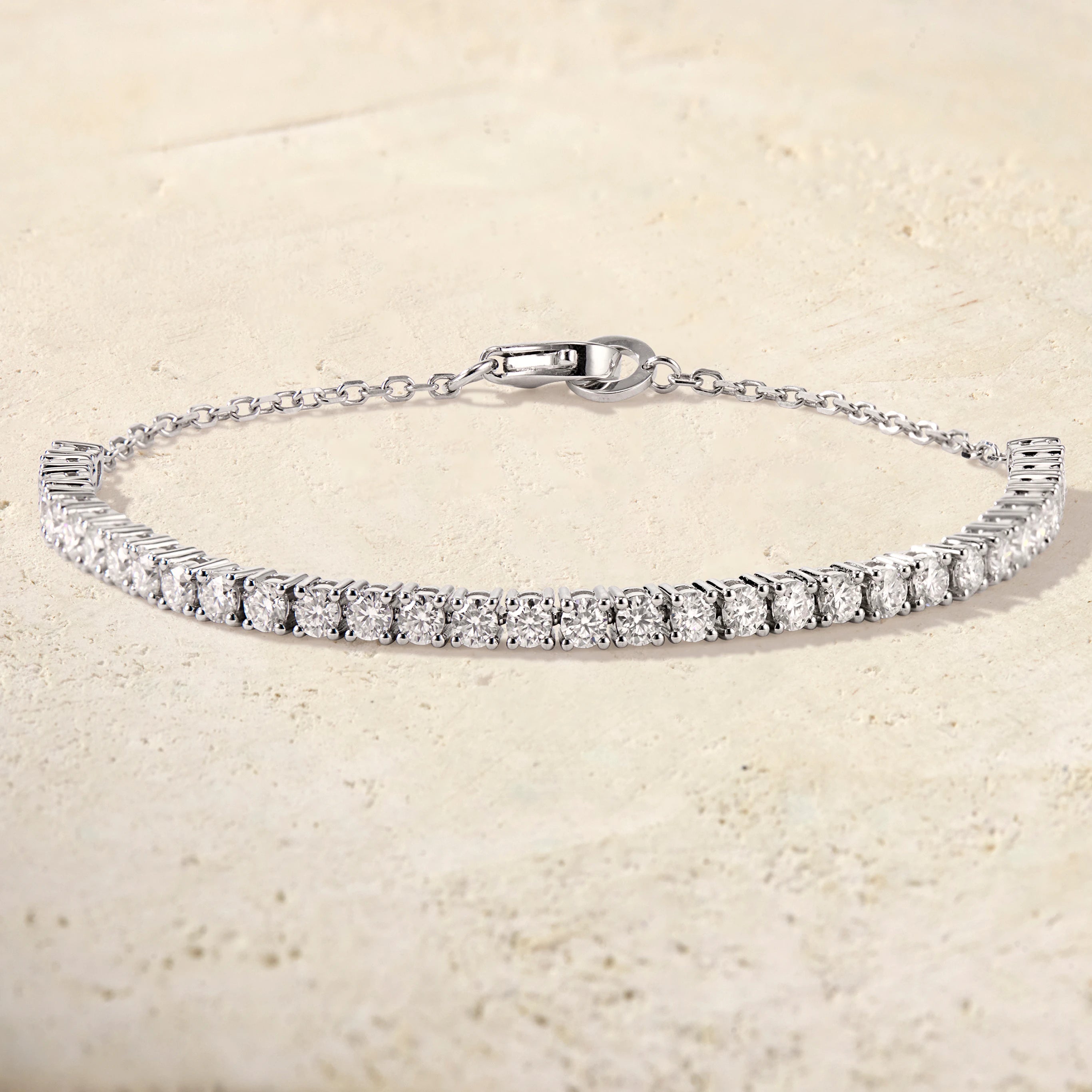 Silver bracelet with clear stones on a beige background